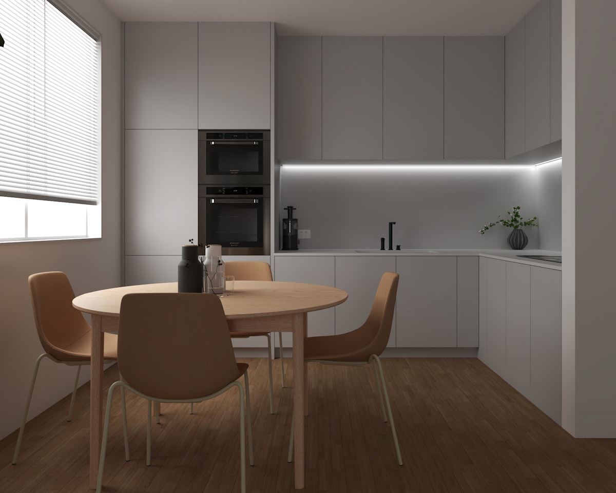 Cocina abierta con mesa junto a la ventana tras la reforma